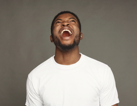 Black man laughing on grey background, studio shot, copy spaceの写真素材