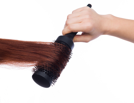 Hair styling with proffesional round hairbrush isolated on white background