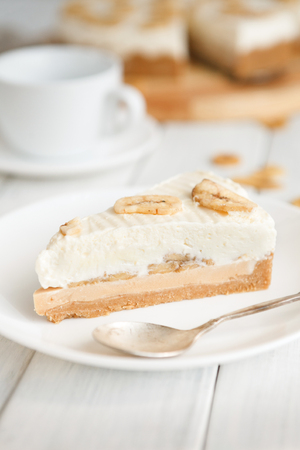 Delicious banana cake on table. Portion of sliced fruit biscuit with caramel and buttercream on wooden catering plate, copy spaceの写真素材