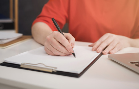 Work planning checklist closeup. Business woman writing on blank paper, cropの写真素材