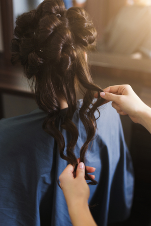 Hairdresser making curly hair to client in beauty salonの写真素材