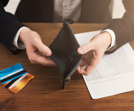 Man showing empty wallet without cash, using only credit cards. Modern lifestyle, lack of money in...
