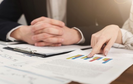 Two investment consultants discussing company balance, working with graphs. Concept picture of economy, market, money and tax, copy spaceの写真素材