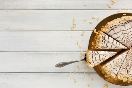 Esterhazy cake sliced on white plate top view. Delicatessen sweet dessert with almond meringue dough and buttercream, traditional hungarian, austrian cuisine, copy spaceの写真素材