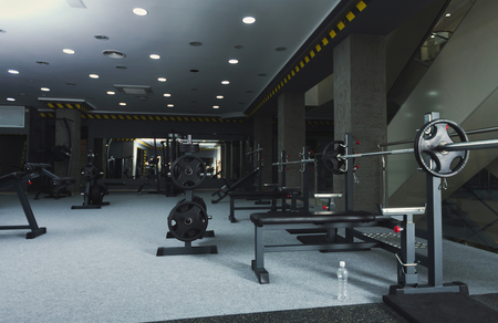 Modern gym interior with weightlifting equipment. Fitness background. Healthy lifestyle, bodybuilding concept, copy spaceの写真素材