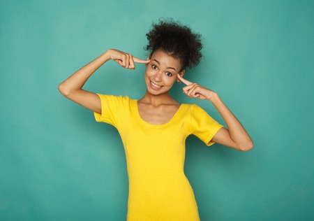 Happy black woman pointing at her head. Young smiling girl with brain explosion, brainstorming and...