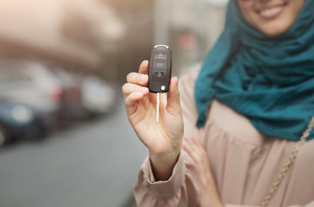 Muslim woman in hijab with car key in city center, selective focus, copy spaceの写真素材