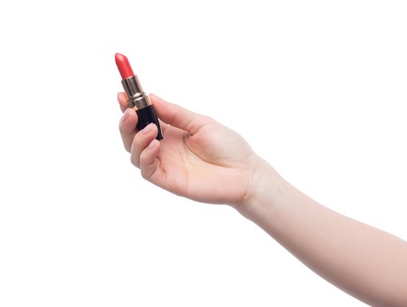Woman holding red lipstick in her hand over white backroundの写真素材