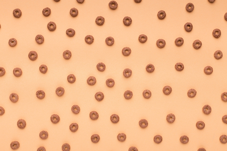 Chocolate cereal pattern on orange background, top viewの写真素材