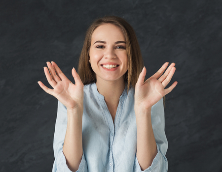Happy surprised excited woman over black studio background. Expressive people, happiness and success conceptの写真素材