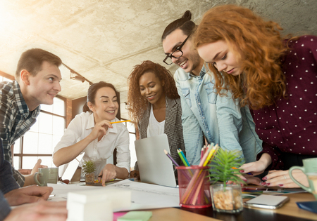 Group of young architects brainstorming in office, discussing blueprint on table, copy spaceの写真素材