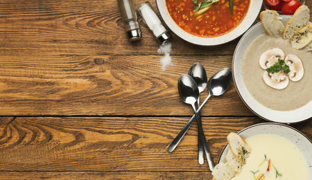 Restaurant lunch menu. Russian saltwort, French mushroom and cheese cream soup with croutons on wooden table, top view, copy spaceの写真素材