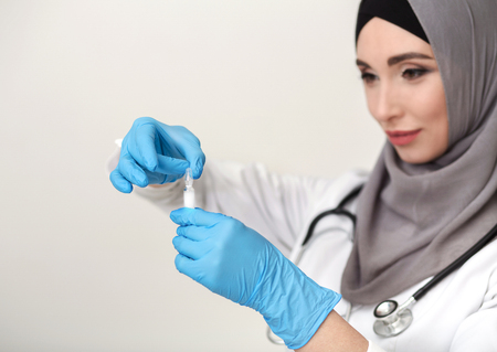 Female islamic doctor preparing medicine for injectionの写真素材