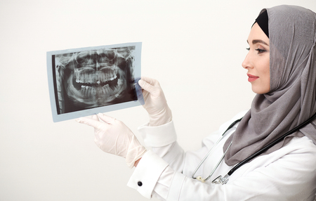 Arab woman dantist holding teeth x-ray photographyの写真素材