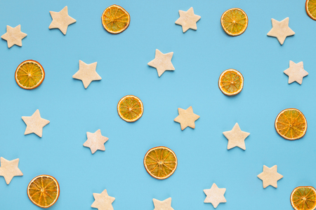 Christmas minimalism. Ginger cookies and dry oranges composition on blue background, top viewの写真素材