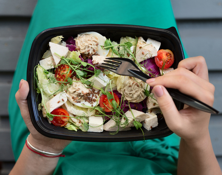 Food delivery service. Woman eating healthy food at lunch time, pov shotの写真素材