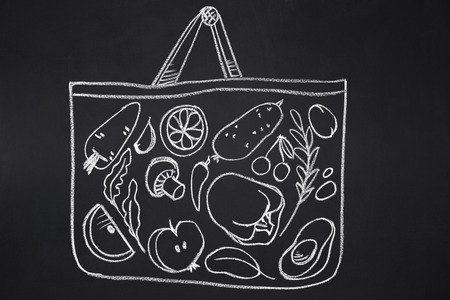 Shopping and healthy eating concept. Bag with vegetables drawn on chalk boardの写真素材