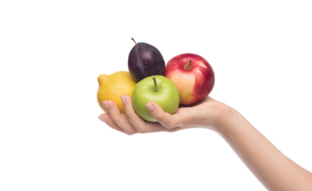 Fruit assortment. Woman holding apples, plum and lemon isolated on white backgroundの写真素材