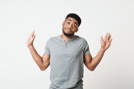Its not me. Confused african-american man raising his hands and looking at camera, white studio...