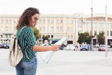 Female tourist holding map while exploring city, copy spaceの写真素材