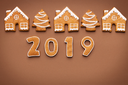 Merry Christmas and Happy New Year 2019. Gingerbread cookies on brown background, top viewの写真素材