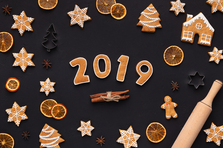 New Year 2019. Homemade gingerbread cookies and dried oranges on dark background, top viewの写真素材