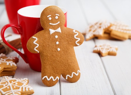 Gingerbread cookie against red cup with cocoa on white table, copy spaceの写真素材