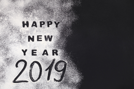 Happy New Year 2019 written on flour on black background, copy space, top viewの写真素材