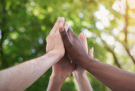 Motivated business team join hands palms together, giving high five.の写真素材