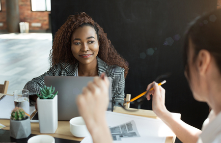 Weekly corporate planning. African-american woman listening to her boss at office, copy spaceの写真素材