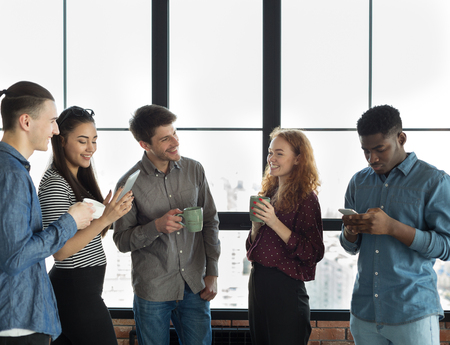 Male and female colleagues resting during break in coworking office, sharing ideas and plans for startup project, copy spaceの写真素材