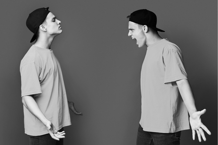 Split personality. Guy having conflict with himself over studio backgroundの写真素材