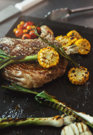 Medium beef steak and vegetables cooked on grill. Healthy exclusive food prepared at professional kithen, closeupの写真素材