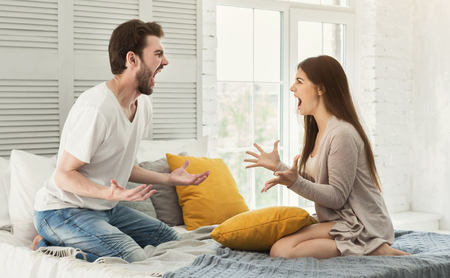Couple shouting in bed, arguing in the morningの写真素材