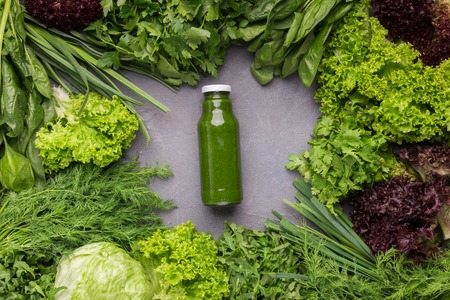 Detox and healthy eating. Bottle of blended green smoothie with ingredients on kitchen table, top viewの写真素材