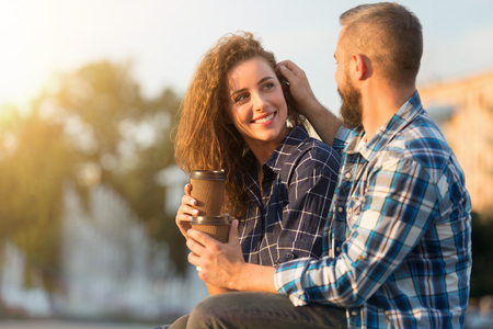 Romantic feelings. Delighted man touching her wifes hair while showing care outdoors, copy spaceの写真素材