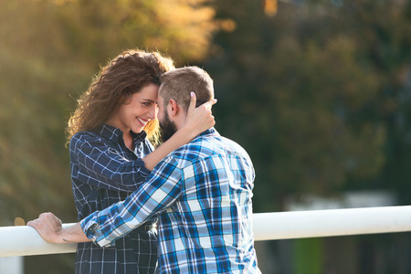 Young couple in love hugging and looking at each other outdoorsの写真素材