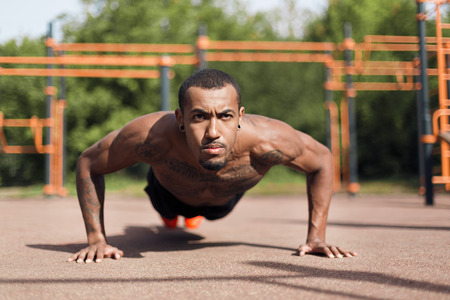 Shirtless african-american man doing push ups, working out