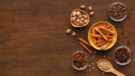 Winter spices concept. Set for mulled wine or Christmas gingerbread on wooden background, copy space, top viewの写真素材