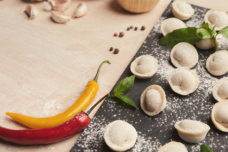 Uncooked dumplings at cutting board. Homemade preparation food.の写真素材
