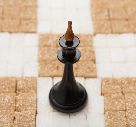 Chess board made of white and brown sugar with black King piece