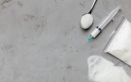 Sugar addiction. Injection with needle filled with sugar on gray concrete background. Top view with copy spaceの写真素材