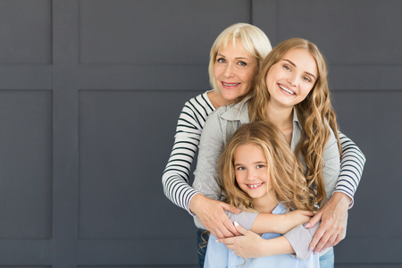 Maternal protection. Women hugging, looking at camera and smiling, copy space