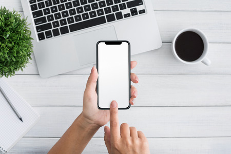 Woman hands holding cell telephone with blank screen for your advertising text message or promotional content, copy spaceの写真素材