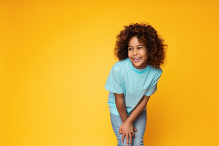 Cute african-american girl posing over yellow studio background, copy spaceの写真素材