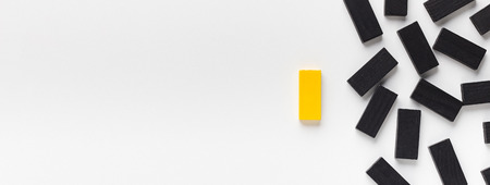 Not like others, individuality and uniqueness concept. Yellow block standing out of black ones, panorama, copy spaceの写真素材