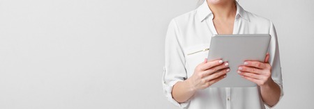 Modern woman using digital tablet computer over grey studioの写真素材