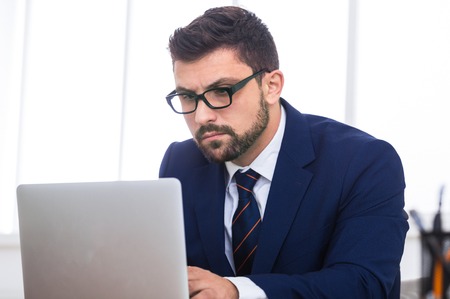 Businessman executive working on laptop, doing report in officeの写真素材