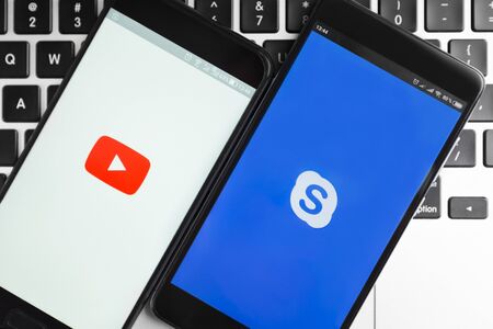 Kharkiv, Ukraine - December 11, 2018: two iPhones with running Skype and Youtube applicationsのeditorial素材