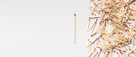 Concept of individuality, leadership, diversity and being unique. One unused matchstick standing out of crowd on white background, panorama, copy spaceの写真素材